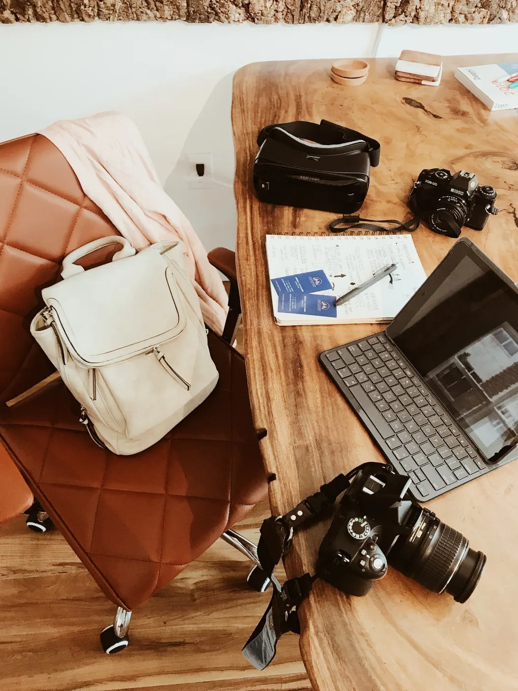 Desk set with two cameras, notebook, and tablet mid-shoot planning