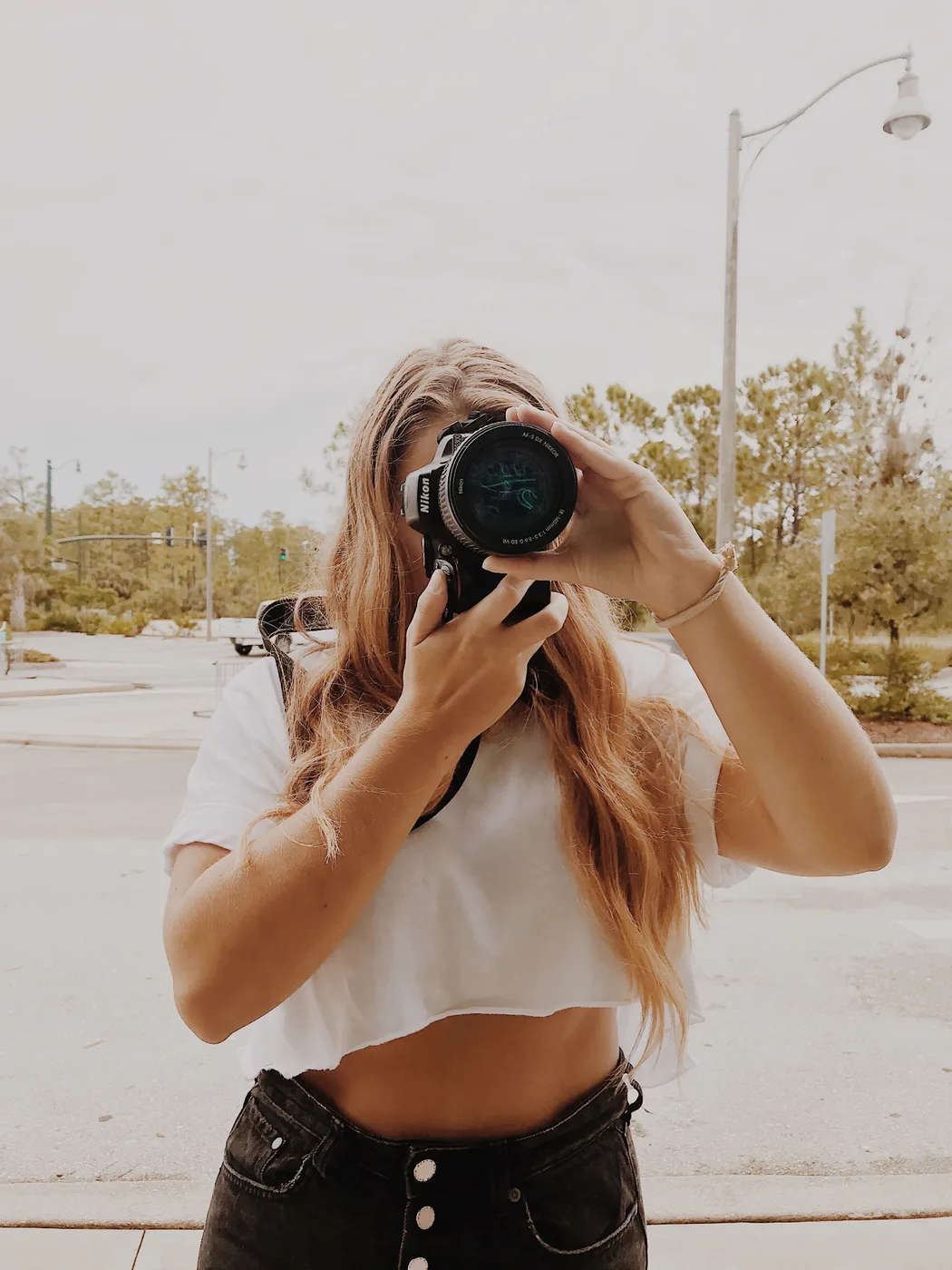 Blue Sitten framing a shot with a DSLR outdoors